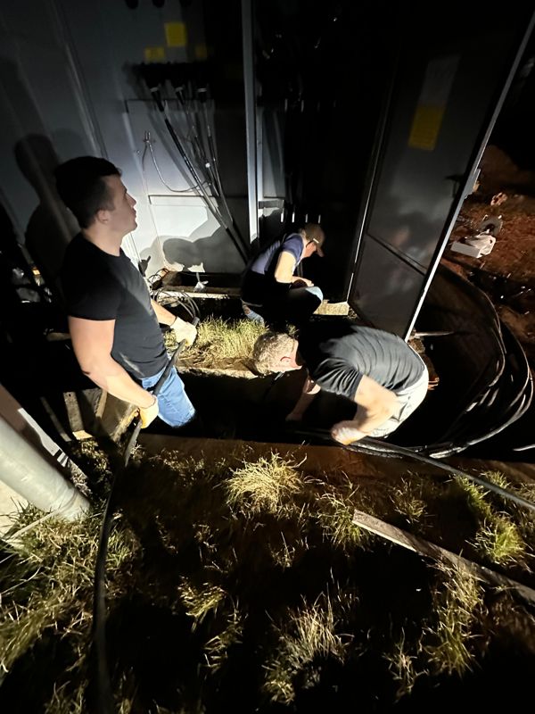 Pulling the power cables into the container — after dark.
